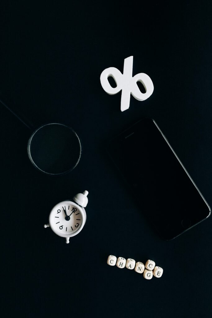 pexels-photo-6120215-6120215 Stylish composition of clock, symbols, and text representing financial change on a dark background.